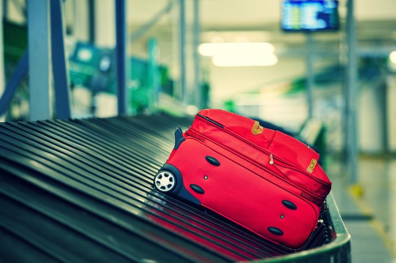 Hành khách làm việc với nhân viên tại quầy Hành lý thất lạc (Lost & Found) của sân bay để báo cáo hành lý không tìm thấy trên băng chuyền